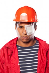 Sad dark-skinned worker with helmet and injured eye